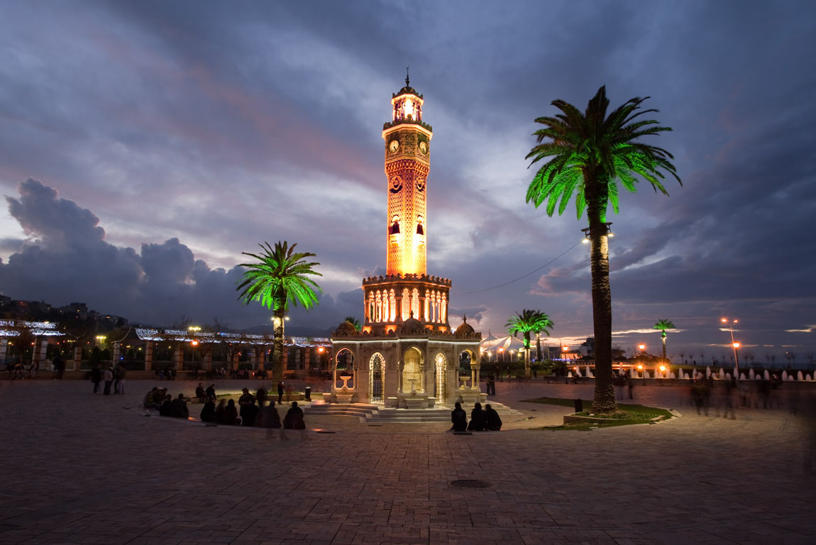Clock tower and palm trees at night at Izmir